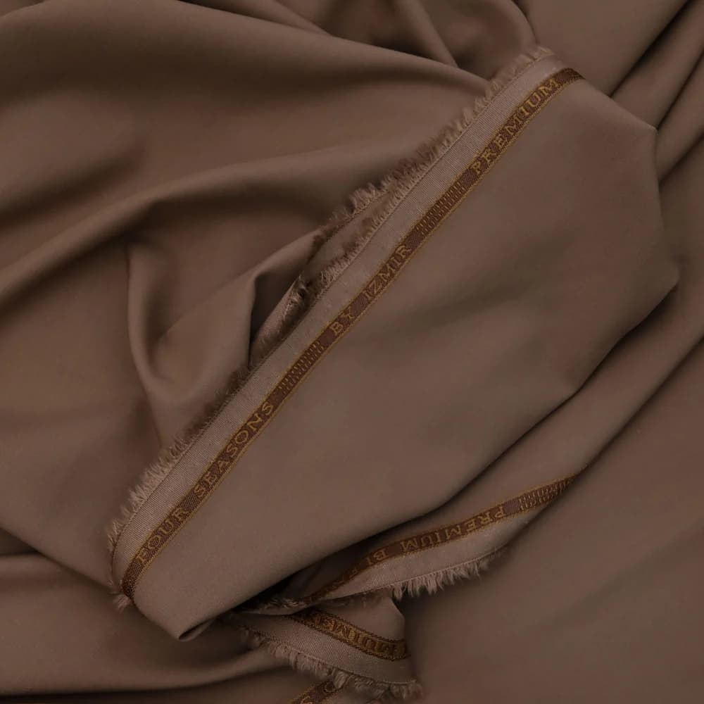 A neatly folded undyed cream wool throw blanket