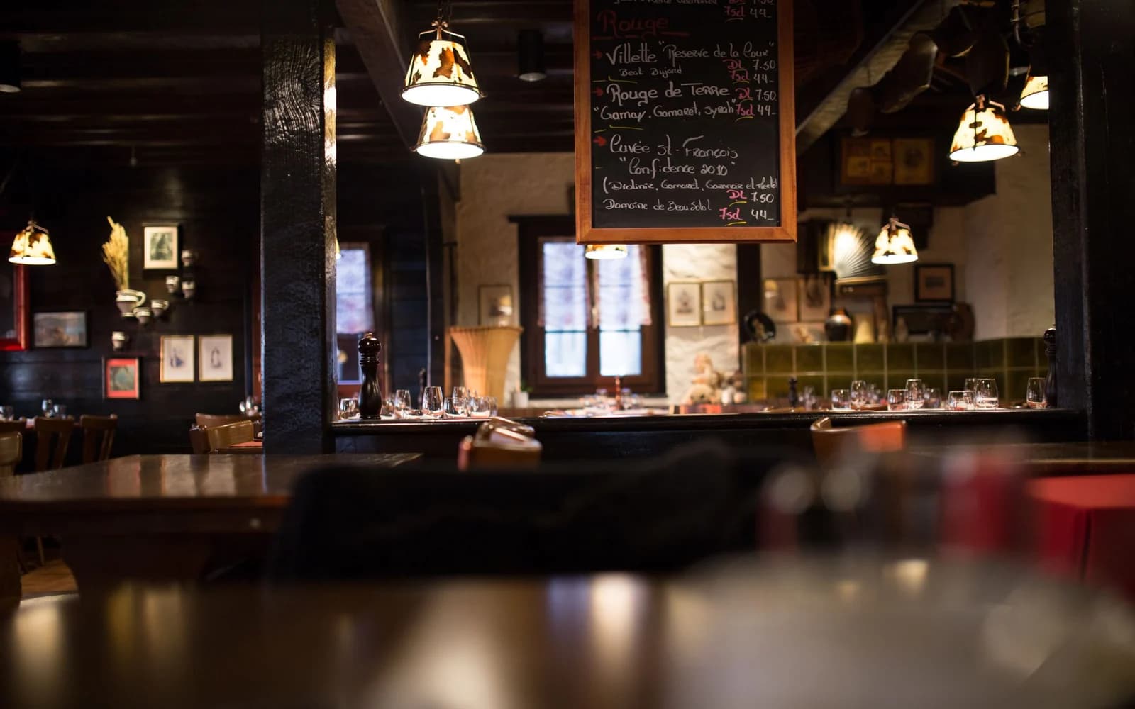 The dining room at The Local Table: long shared tables under string lights against brick